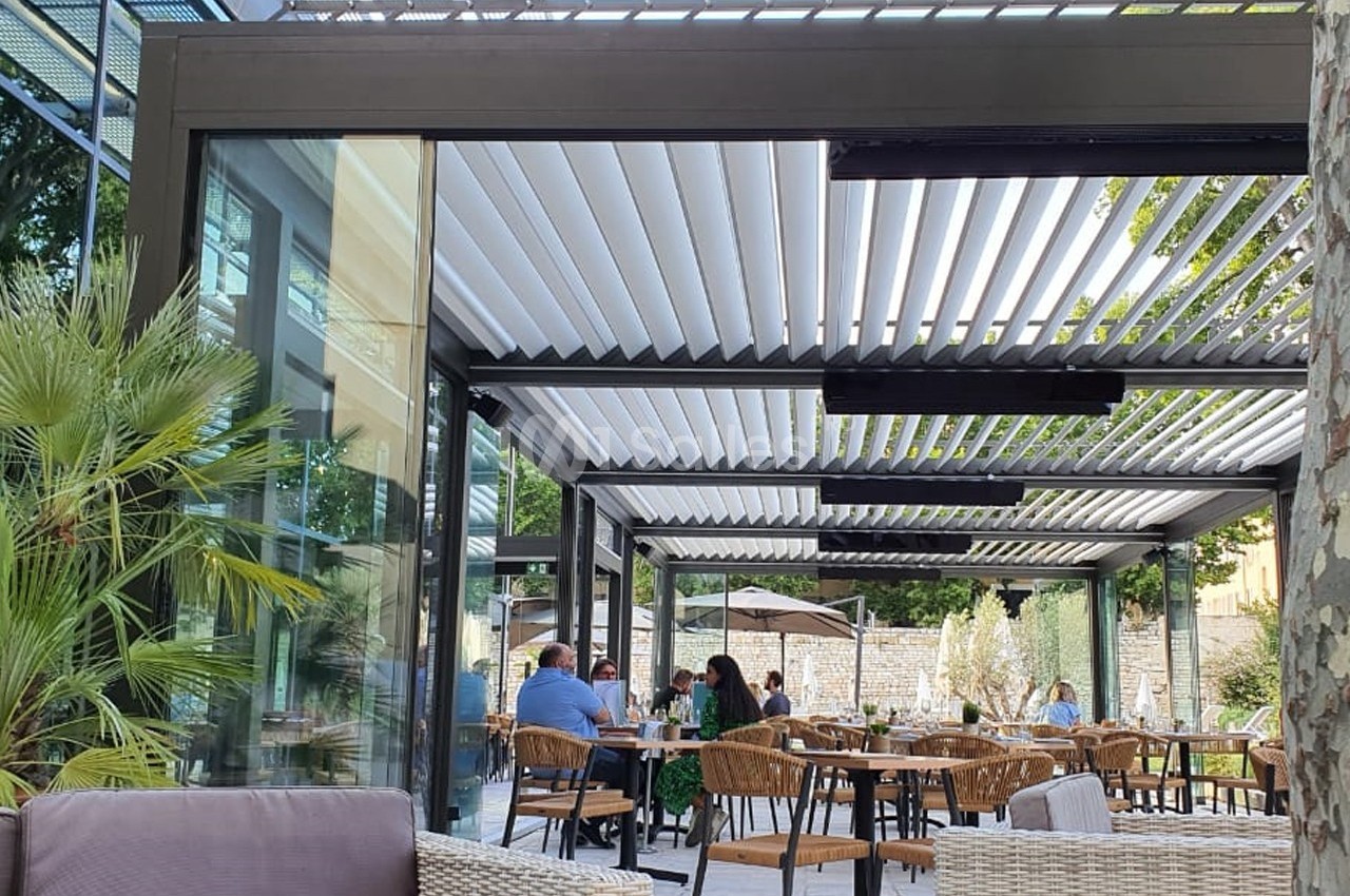 Terrasse extérieure moderne avec pergola à lames orientables, tables et chaises occupées par des clients.