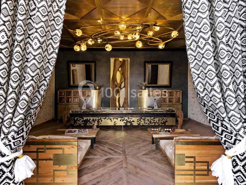 Intérieur élégant avec rideaux à motifs, mobilier en bois, lustre doré et décoration murale raffinée.