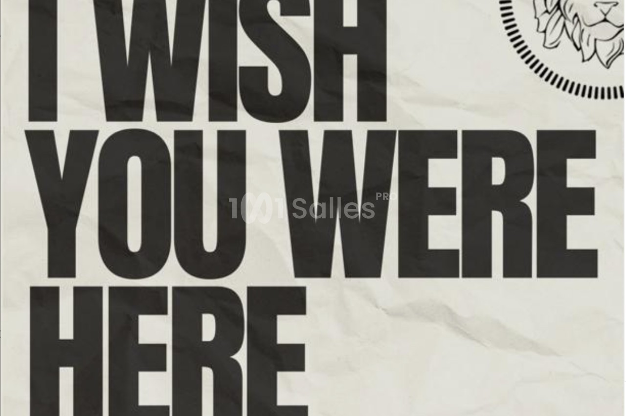 Texte en majuscules ’I WISH YOU WERE HERE’ sur fond texturé beige, avec un logo de lion en haut à droite.