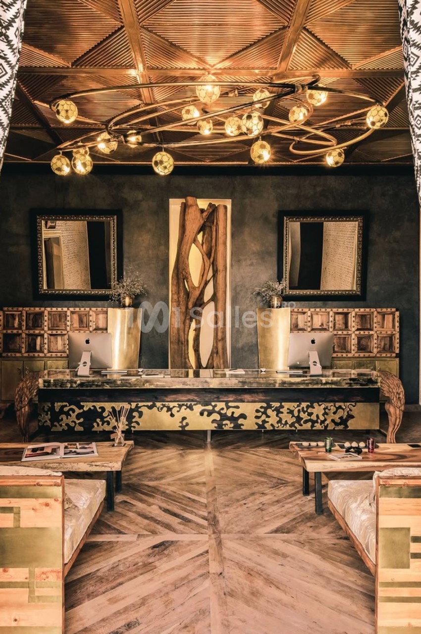 Intérieur élégant avec un bureau en bois sculpté, lustre doré moderne et décorations murales géométriques.
