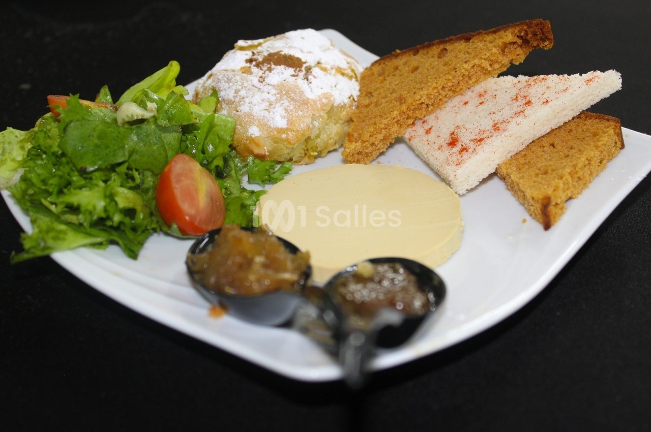 Assiette composée de salade verte, tomate, pain, fromage, confitures et pâtisserie saupoudrée de sucre glace.