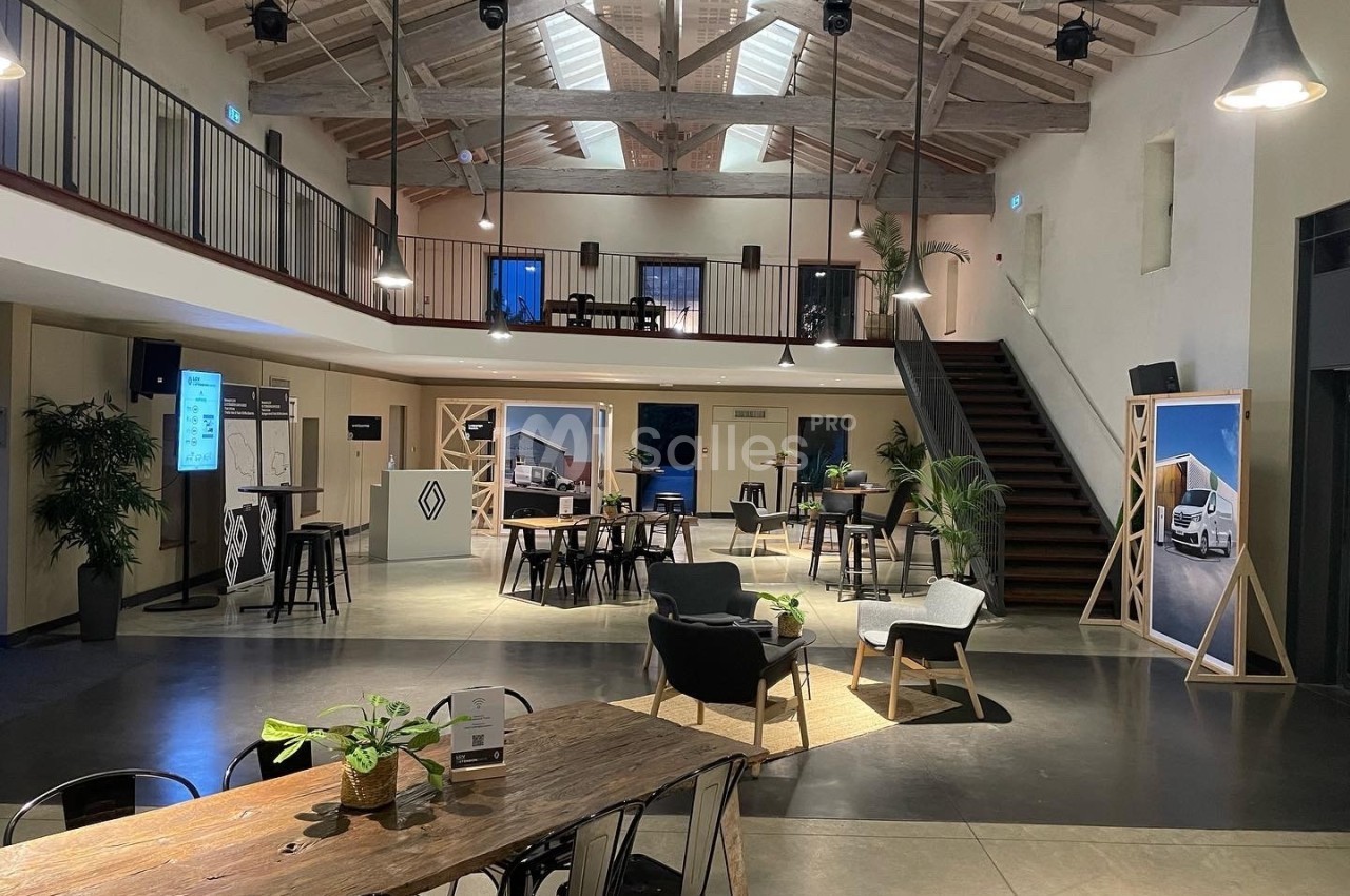 Espace intérieur moderne avec mezzanine, mobilier design, éclairage chaleureux et plantes décoratives.