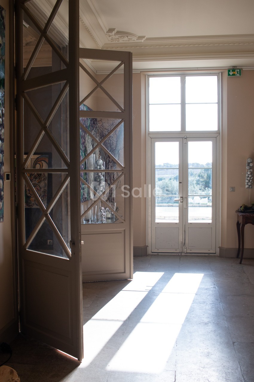 Porte vitrée ouverte laissant entrer la lumière naturelle dans une pièce avec vue sur un paysage extérieur.