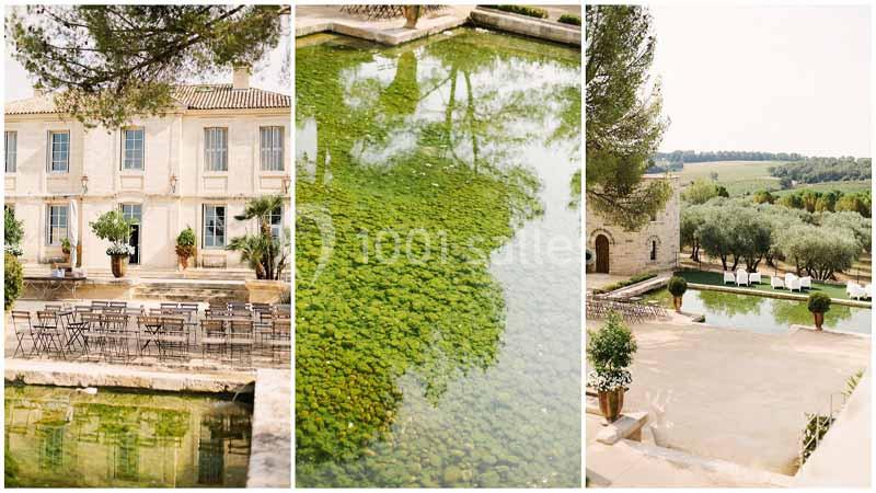Vue d'un domaine avec une bâtisse en pierre, un bassin d'eau verdoyant et une terrasse entourée d'oliviers.