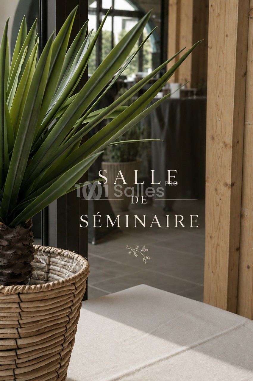 Plante en pot devant une baie vitrée avec l'inscription ’Salle de séminaire’ visible sur la vitre.