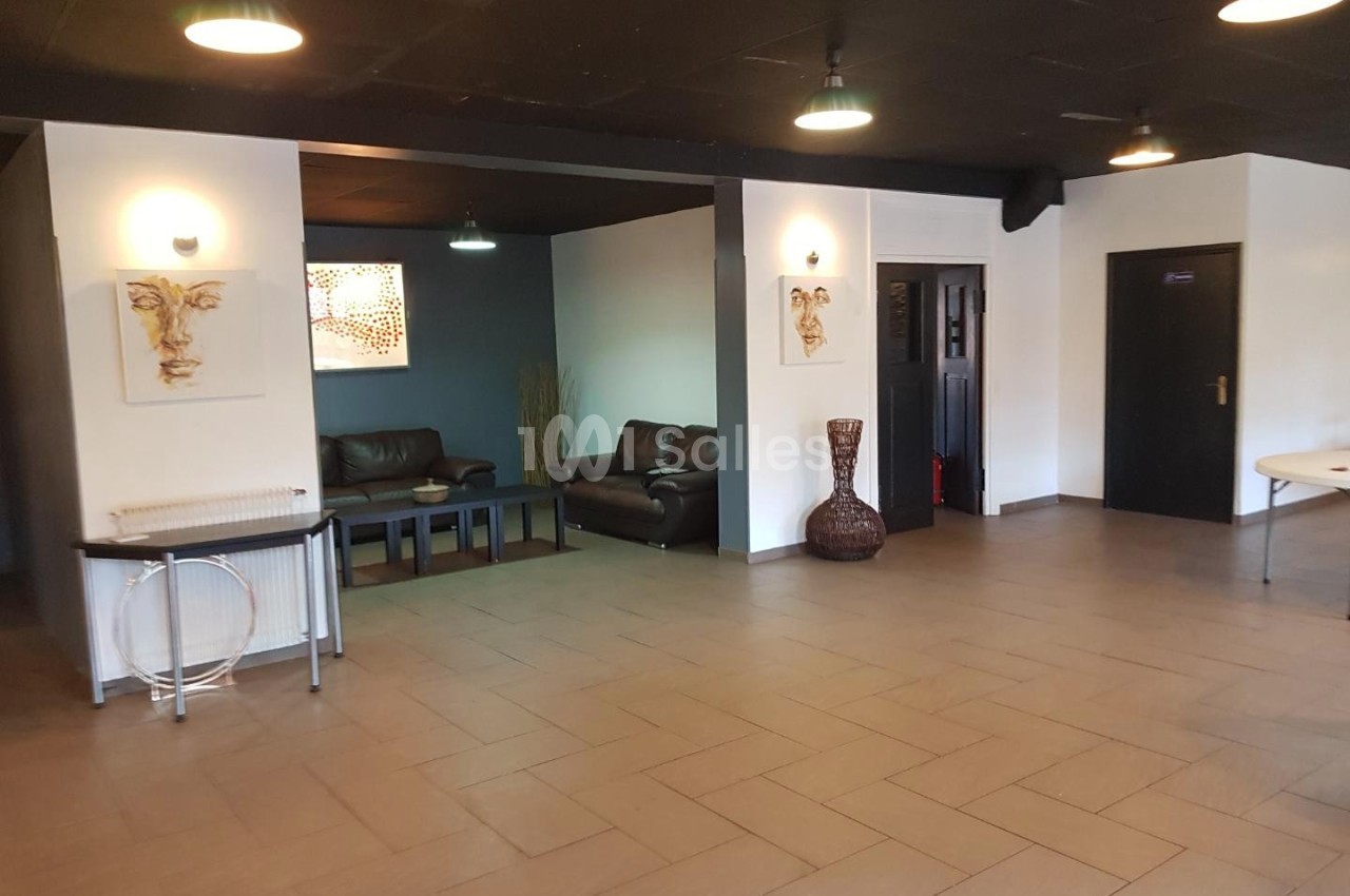 Salle avec un sol carrelé, des canapés en cuir, des décorations murales et un éclairage suspendu.