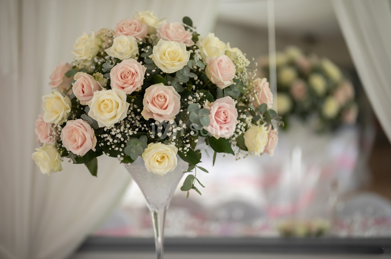 Bouquet de roses roses et blanches avec du gypsophile dans un vase en verre, décoré dans un cadre élégant.