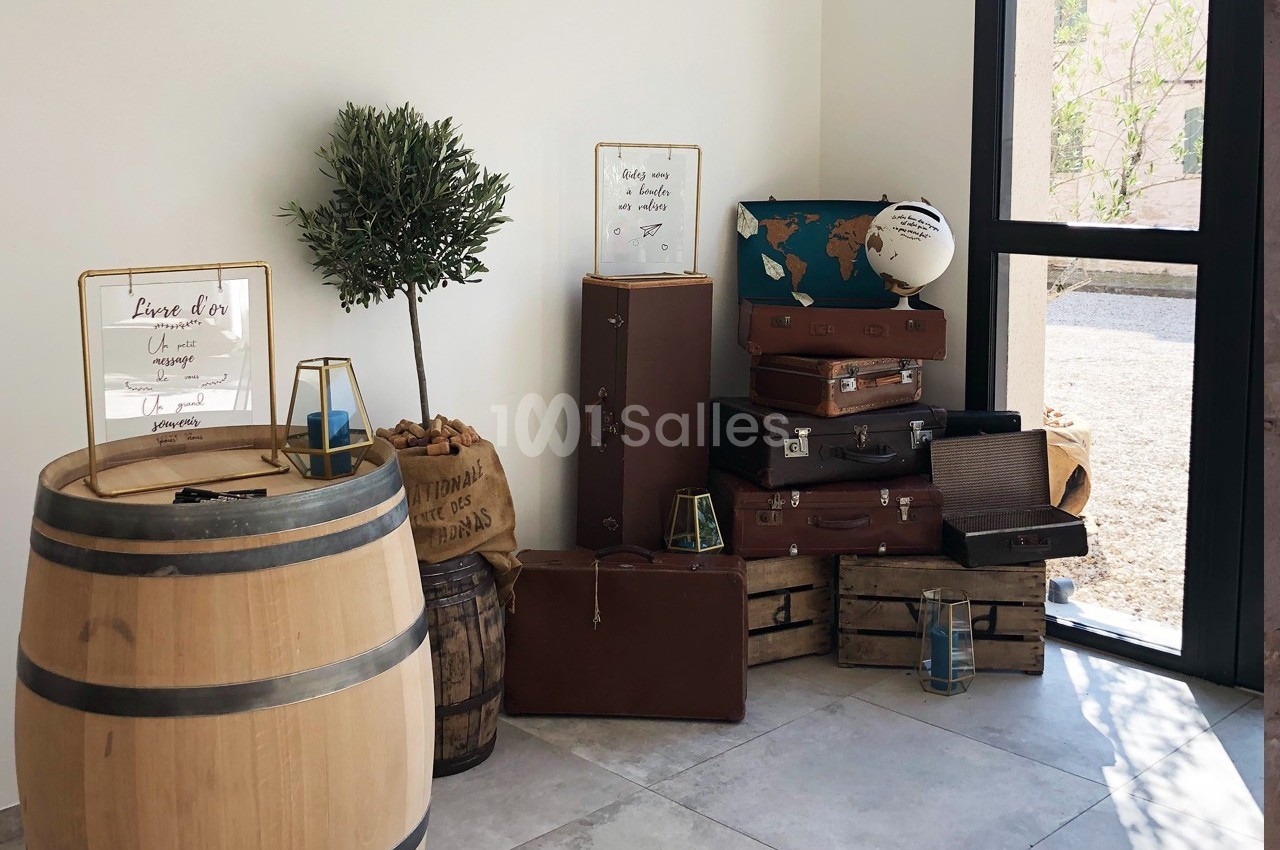 Décoration intérieure avec valises empilées, tonneaux, globe terrestre et panneau sur un tonneau près d'une fenêtre.