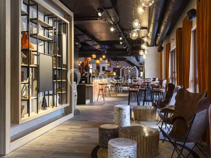 Espace intérieur moderne avec mobilier en bois, éclairage suspendu et ambiance chaleureuse.