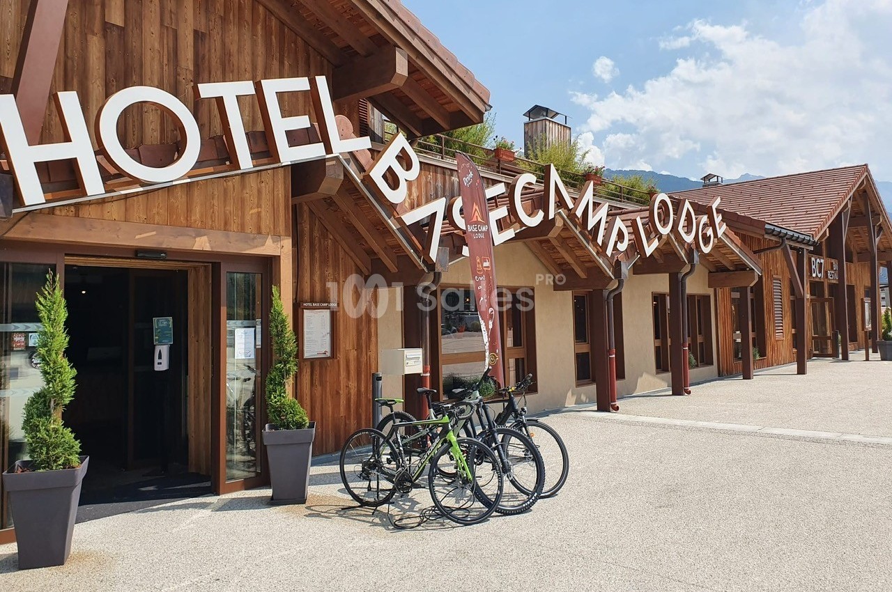Façade en bois d'un hôtel avec des vélos stationnés devant, sous un ciel dégagé.