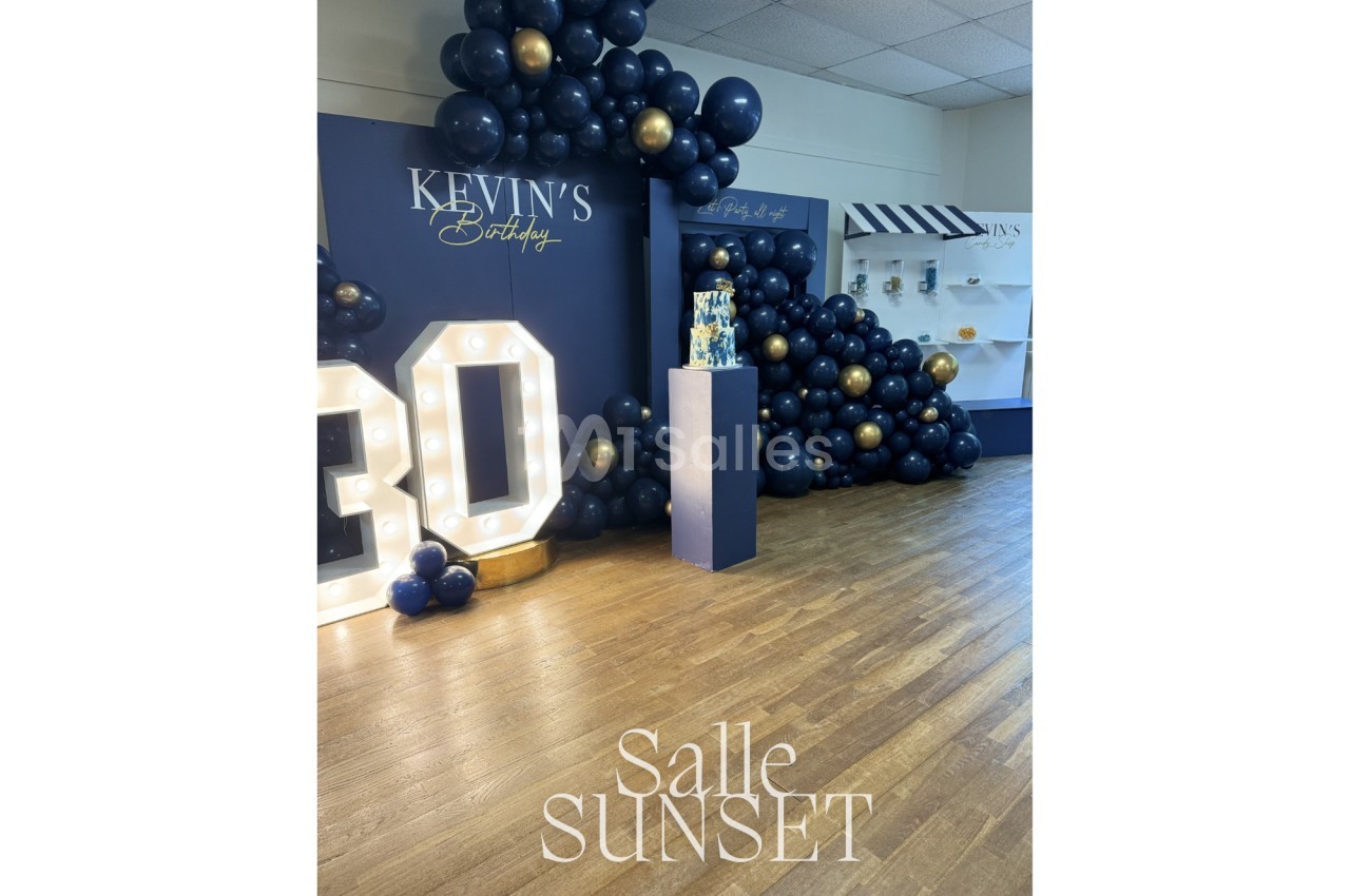 Décoration d'anniversaire avec ballons bleu marine et dorés, chiffre lumineux ’30’ et présentoir à gâteau.