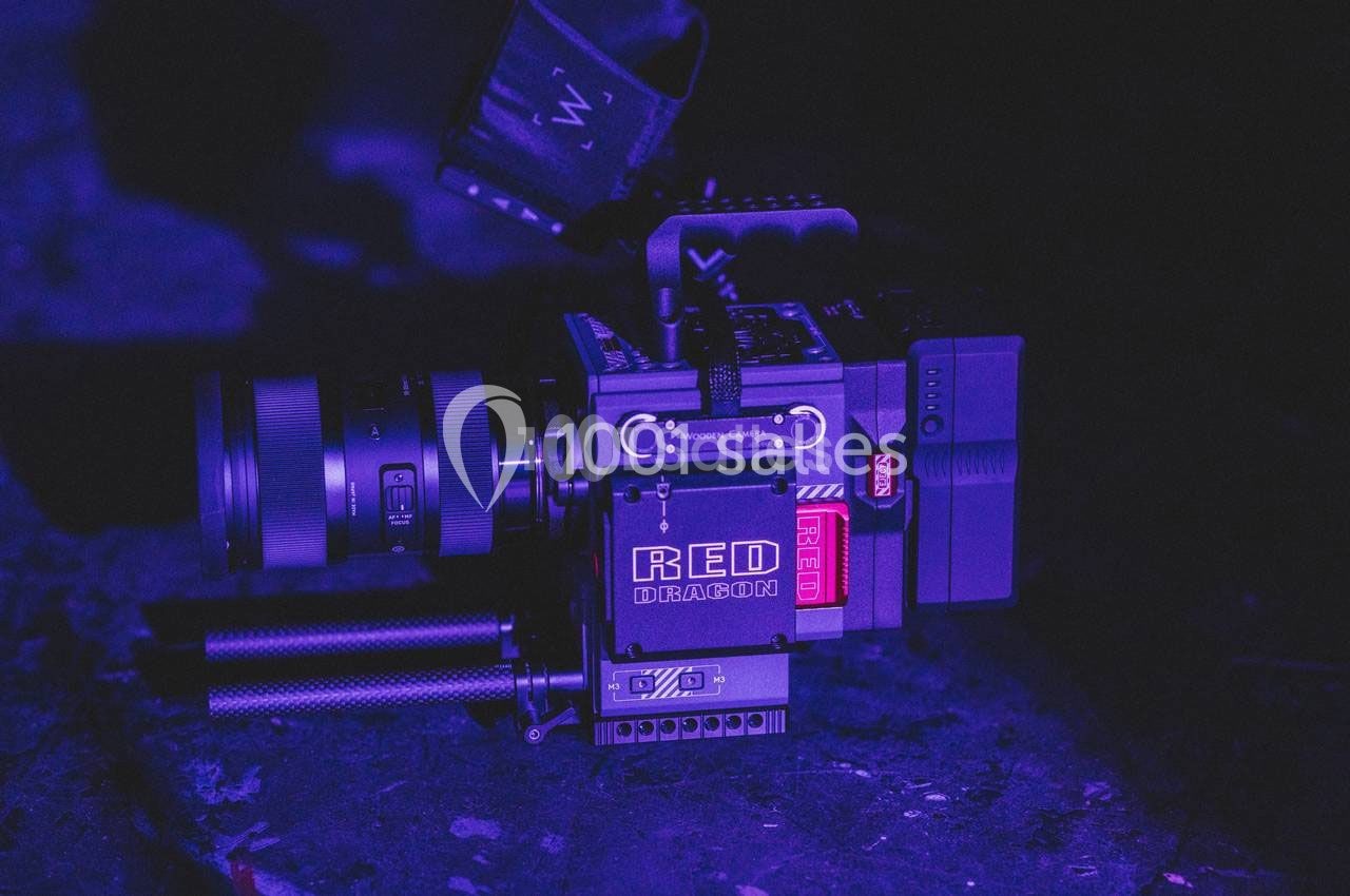 Caméra professionnelle RED Dragon posée dans un environnement sombre avec un éclairage violet.