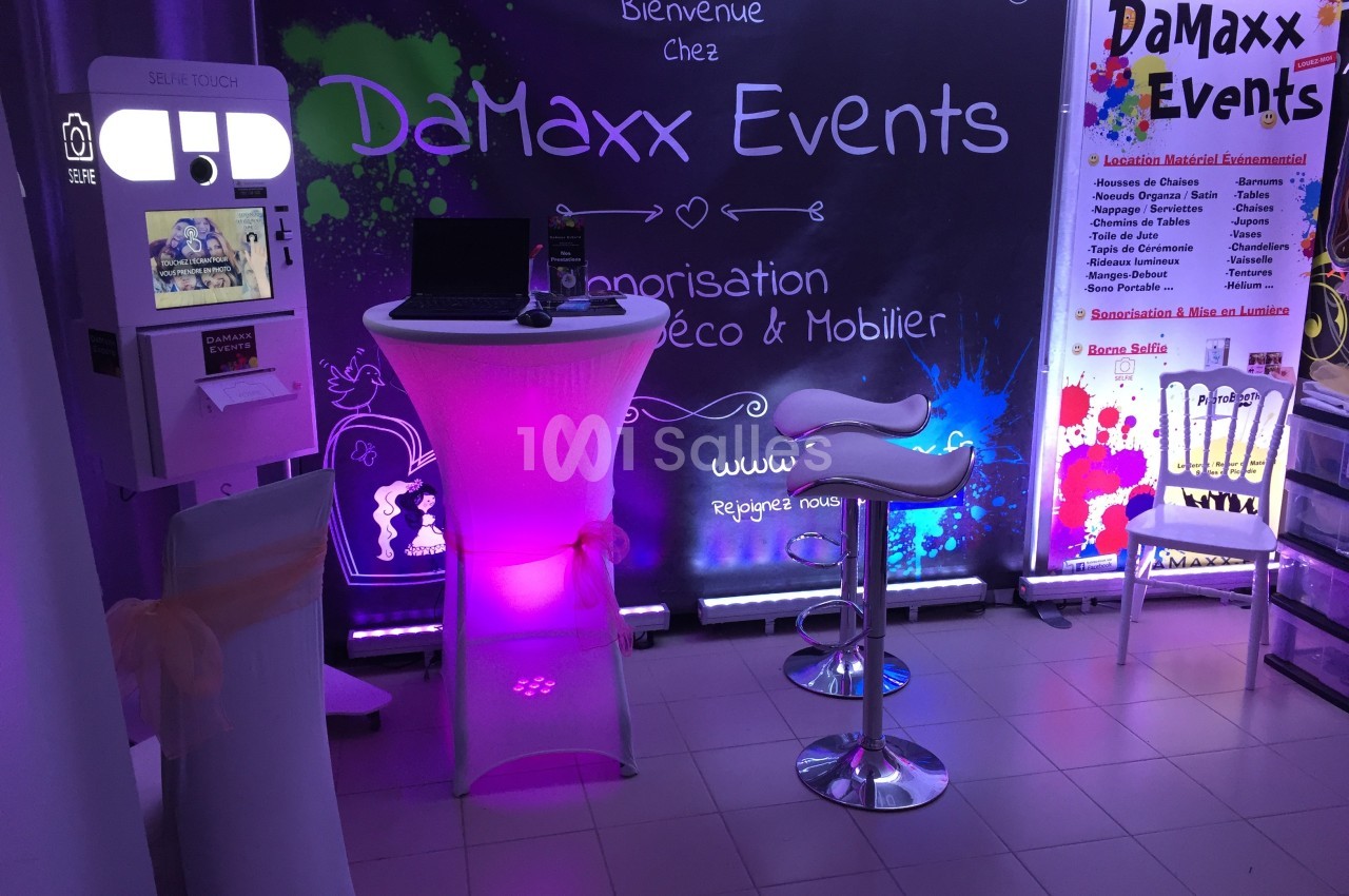 Borne photo et table lumineuse avec tabourets dans un espace décoré aux couleurs de DaMaxx Events.