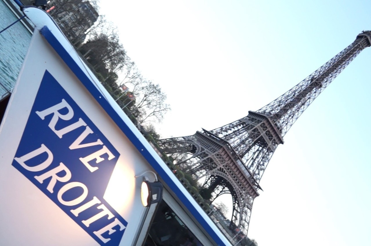 Vue de la Tour Eiffel depuis un bateau avec l'inscription ’Rive Droite’ visible au premier plan.