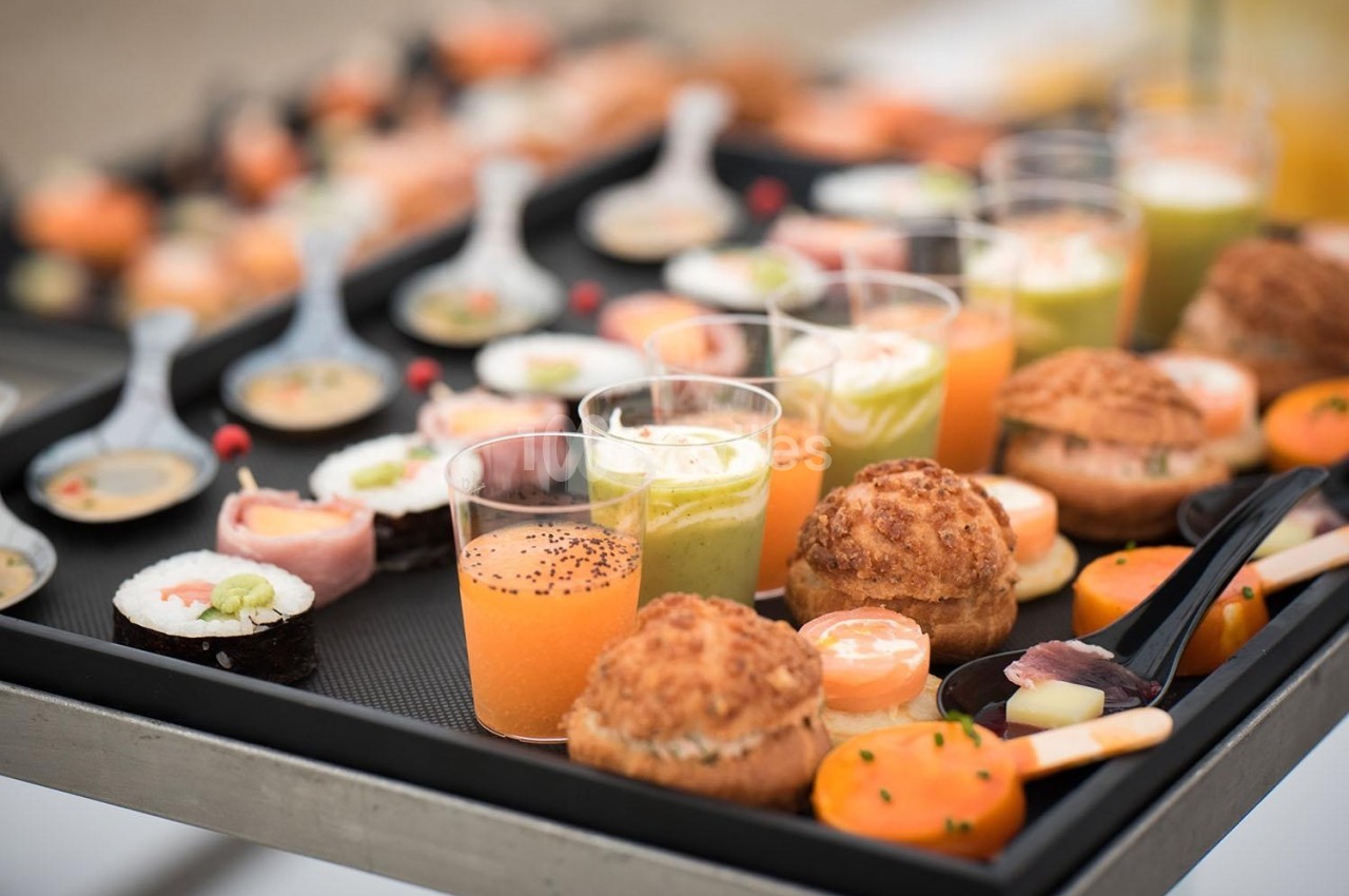 Plateau de bouchées apéritives variées comprenant verrines, sushis, choux salés et cuillères garnies.