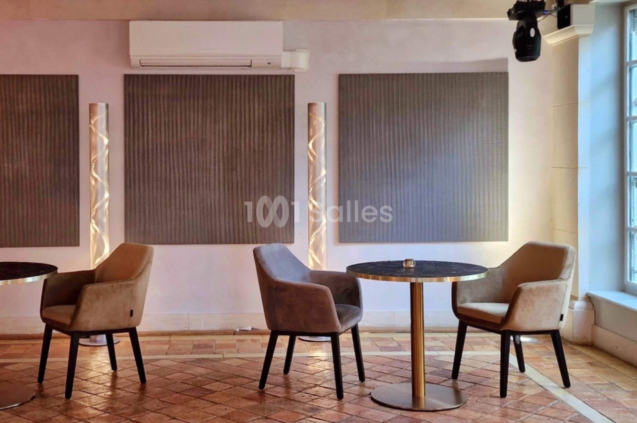 Salle lumineuse avec tables rondes, chaises rembourrées, panneaux muraux décoratifs et grande fenêtre donnant sur l…