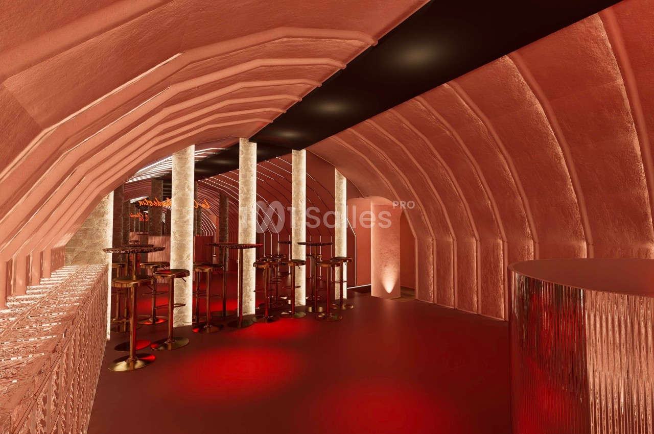 Intérieur d'un espace moderne avec des arches rouges, des colonnes lumineuses et un éclairage tamisé.