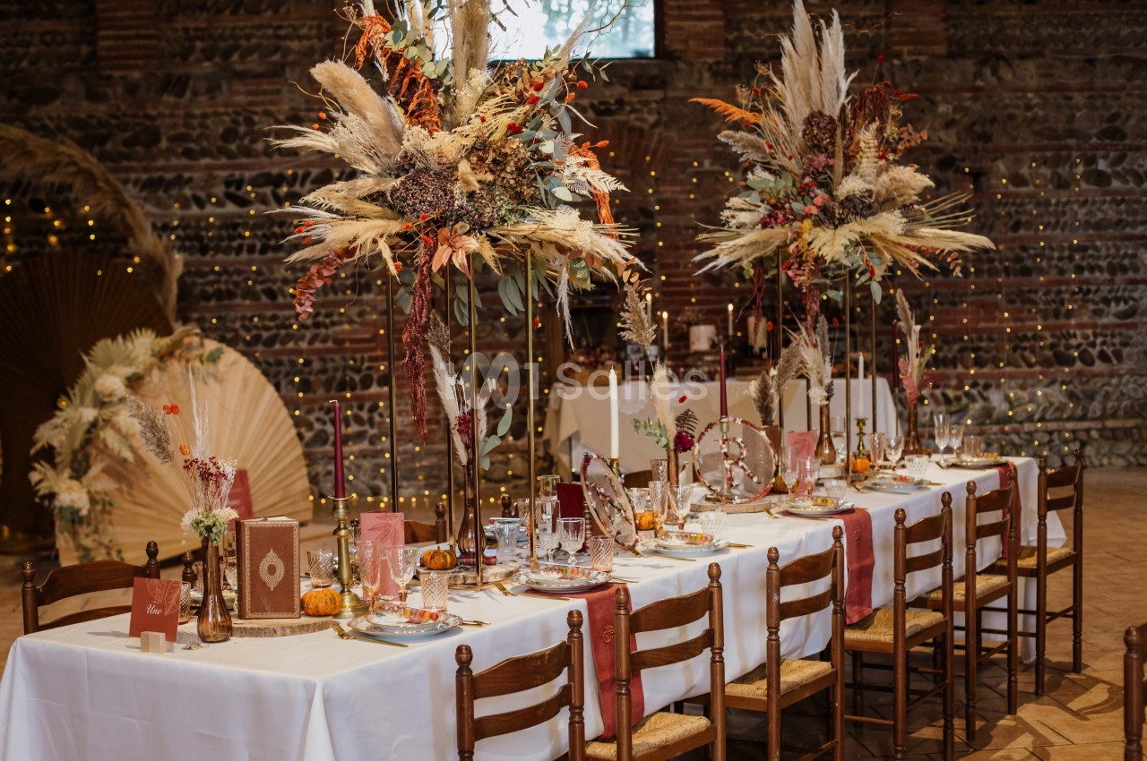 Table de réception décorée dans un style automnal avec fleurs séchées, bougies et vaisselle élégante dans une salle en…