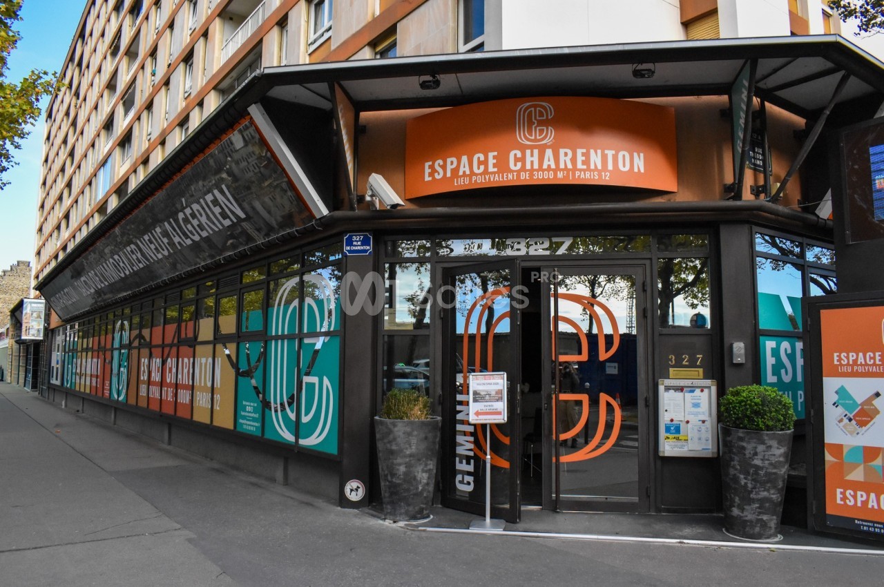 Façade vitrée de l'Espace Charenton à Paris, avec enseignes colorées et entrée principale visible.