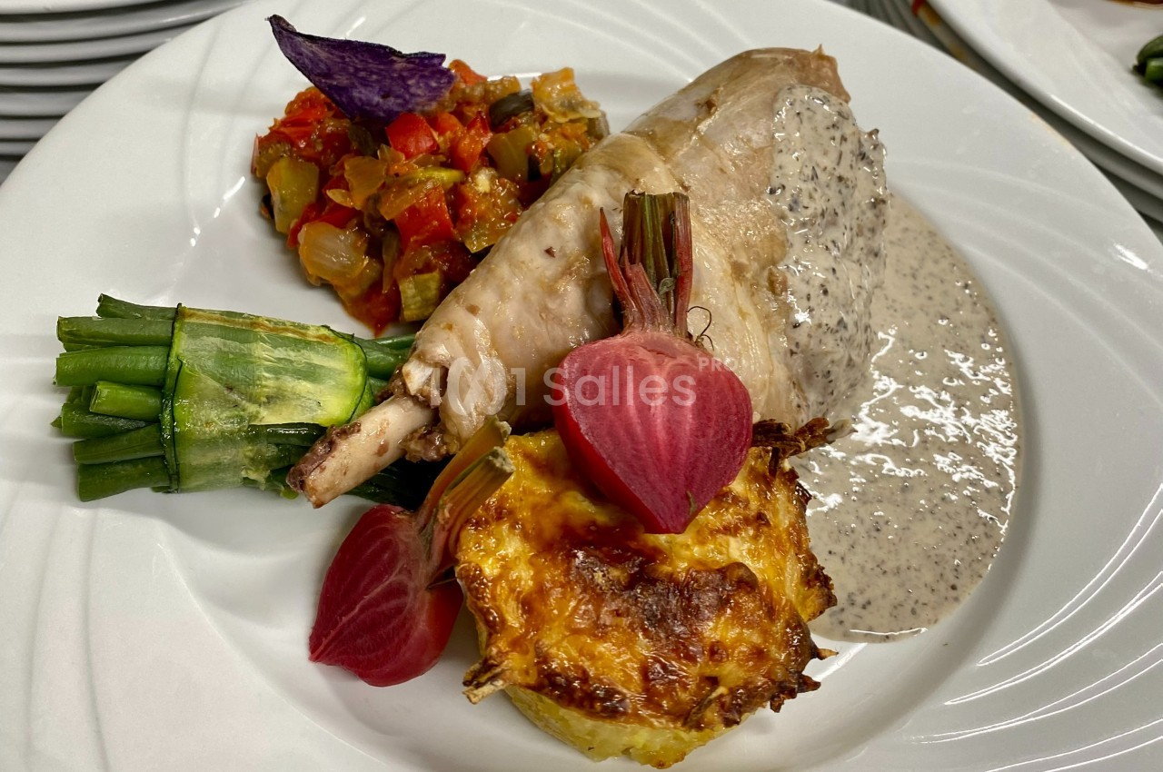 Assiette composée d'une cuisse de volaille, légumes variés, gratin, sauce crémeuse et betteraves en décoration.