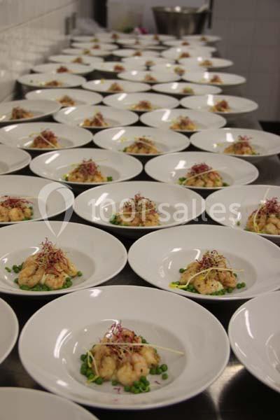 Assiettes alignées contenant des plats à base de légumes verts, de crevettes et de garnitures colorées dans une cuisine…