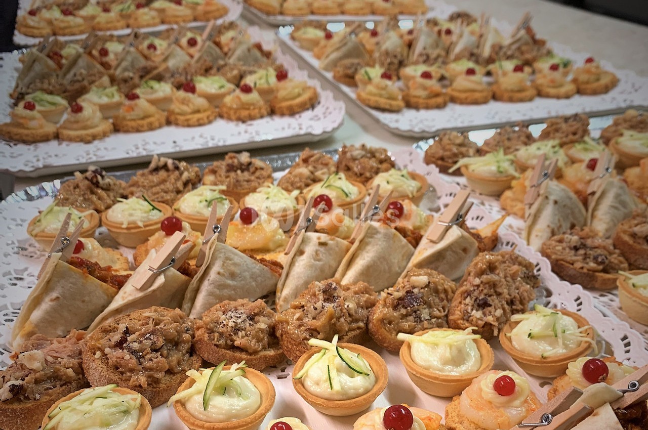 Plateaux de bouchées apéritives variées comprenant tartes, wraps, toasts et amuse-bouches décorés.