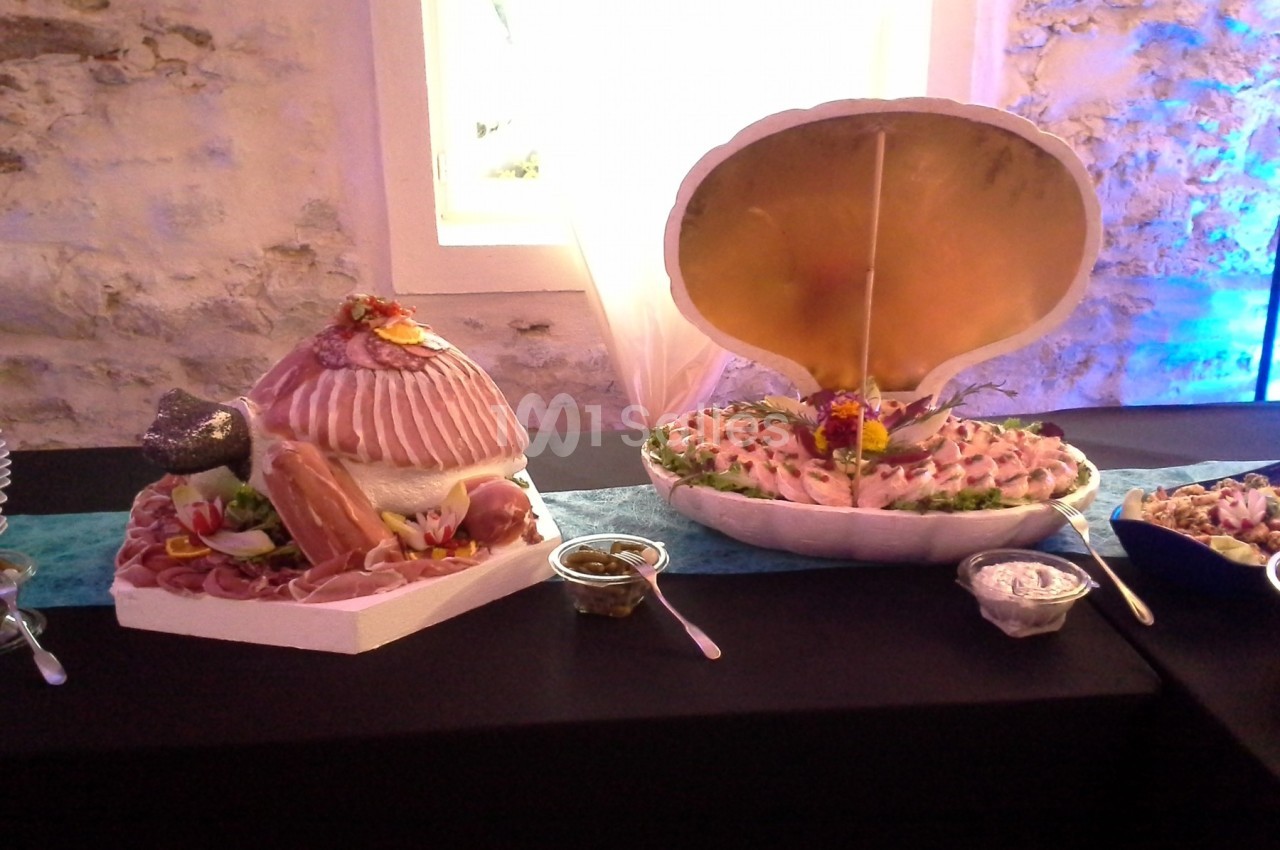 Plateaux de fruits de mer et charcuterie présentés dans des coquilles géantes sur une table de réception.