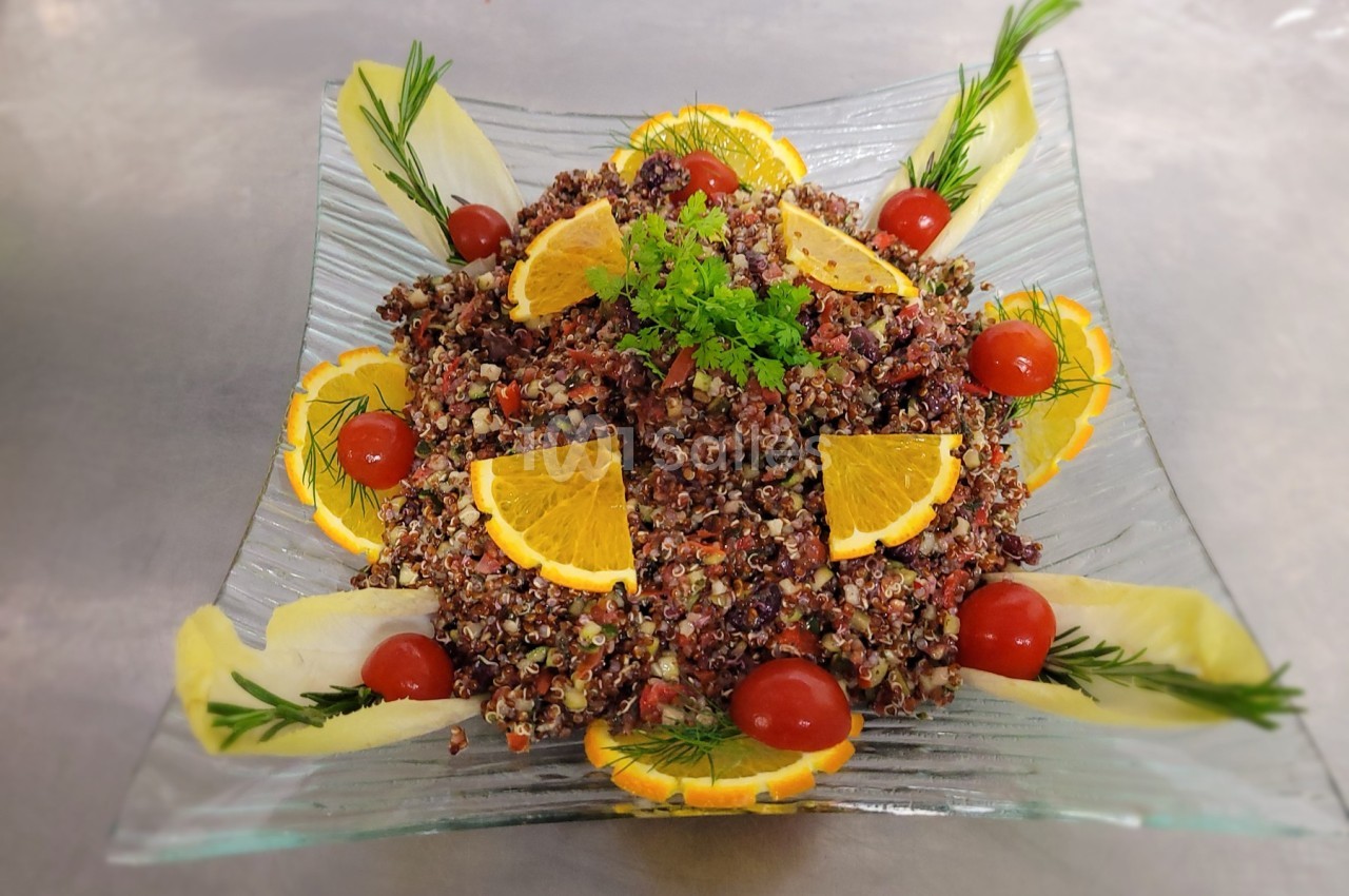 Salade de quinoa colorée garnie de tranches d'orange, tomates cerises, herbes fraîches et feuilles d'endive.