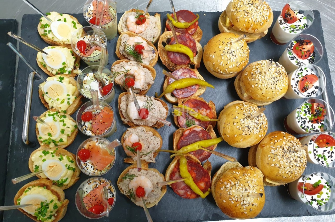 Plateau de bouchées variées comprenant verrines, mini-sandwichs, brochettes et amuse-bouches sur ardoise.