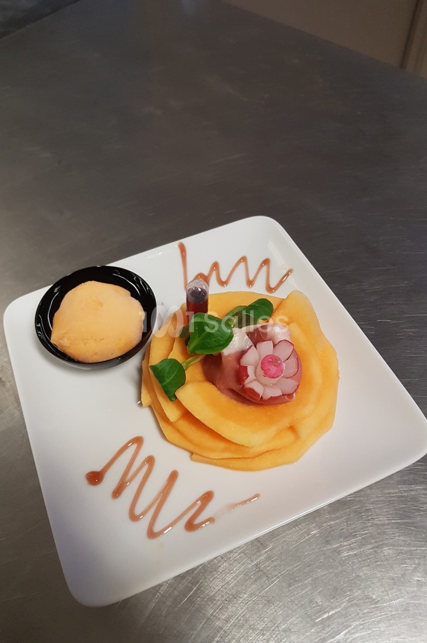 Assiette de carpaccio de melon décoré de radis et herbes, avec une boule de sorbet et un filet de sauce.
