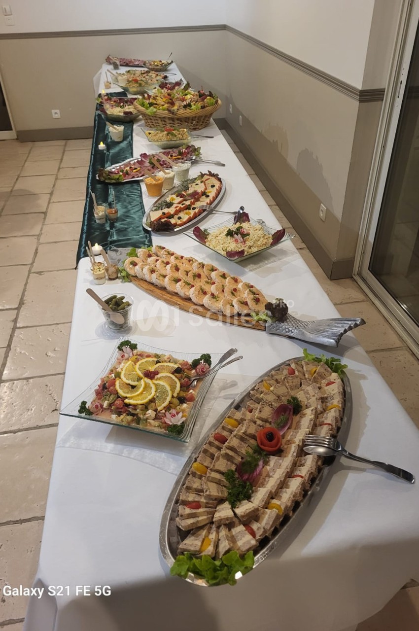 Buffet composé de plats variés, incluant fruits de mer, salades et assortiments de charcuterie, disposés sur une longue…