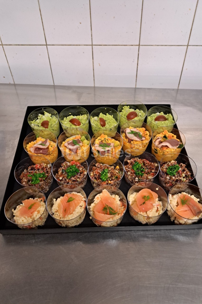 Plateau de verrines variées contenant des préparations salées comme avocat, quinoa, saumon et autres garnitures.