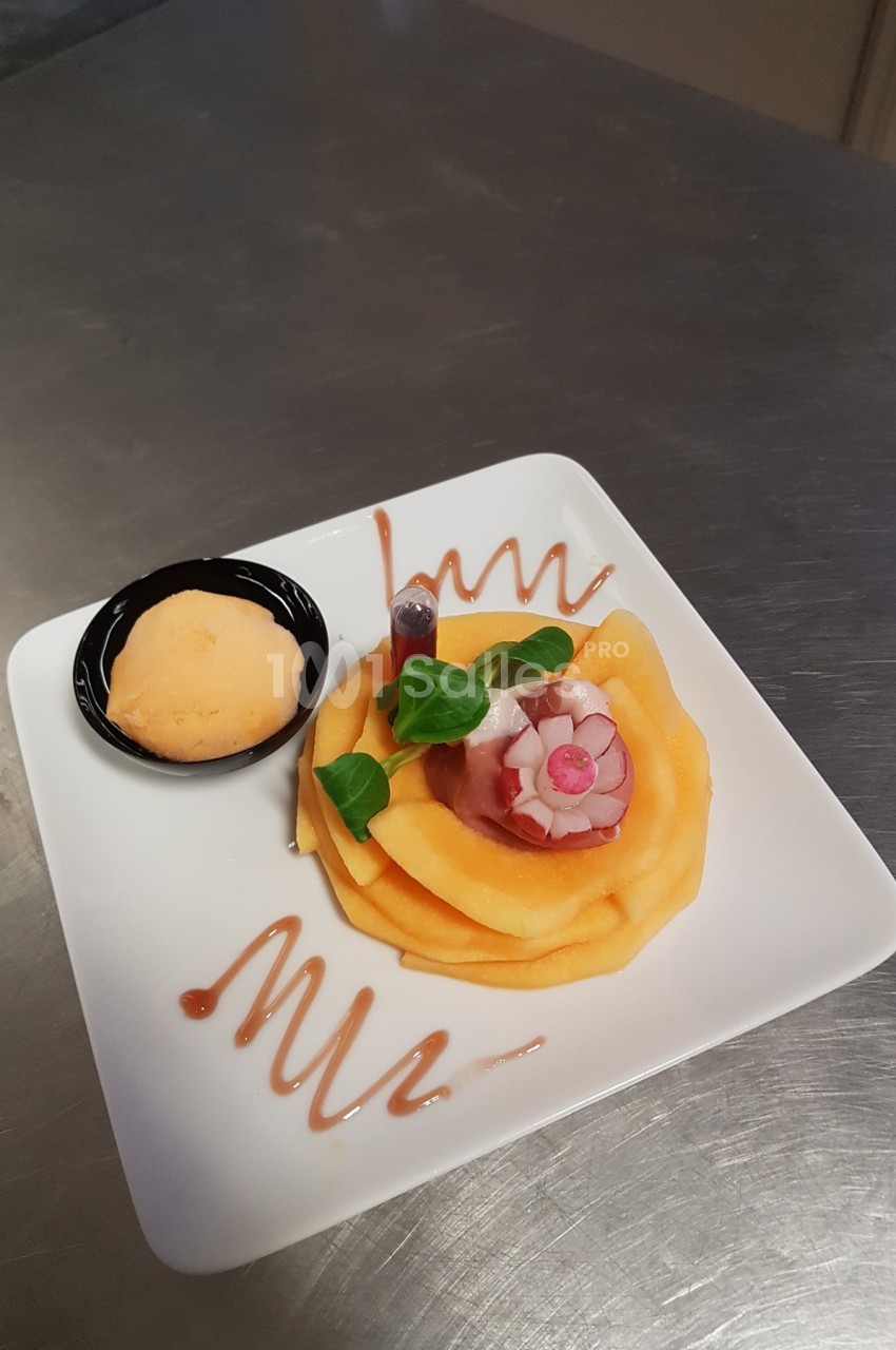 Assiette de carpaccio de melon décoré de radis et herbes, avec une boule de sorbet et un filet de sauce.