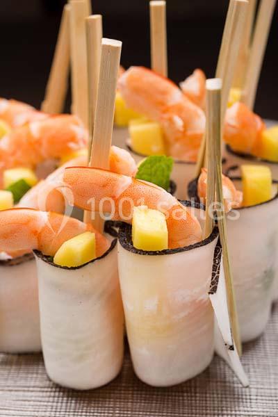 Brochettes de crevettes, morceaux de mangue et feuilles de menthe enroulés dans des tranches de radis noir.