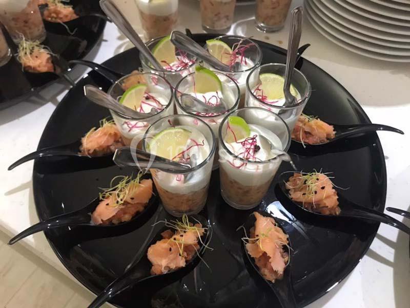Plateau de verrines au saumon avec mousse blanche, rondelles de citron et pousses, accompagné de bouchées au saumon.