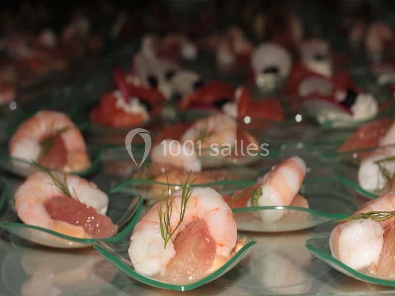 Crevettes servies sur des cuillères transparentes avec des morceaux de pamplemousse et une touche d'aneth.