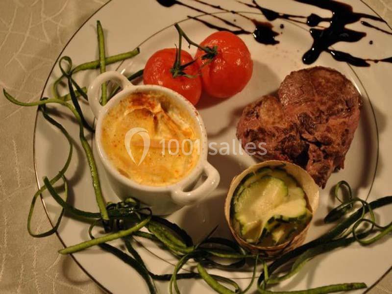 Assiette composée d'un steak en forme de cœur, tomates cerises, gratin, courgettes et filet de sauce balsamique.