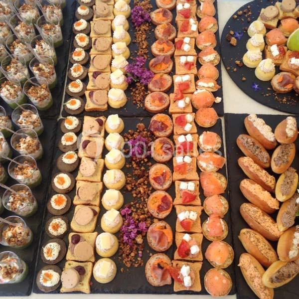 Plateau de bouchées apéritives variées comprenant verrines, tartelettes, toasts et petits pains.