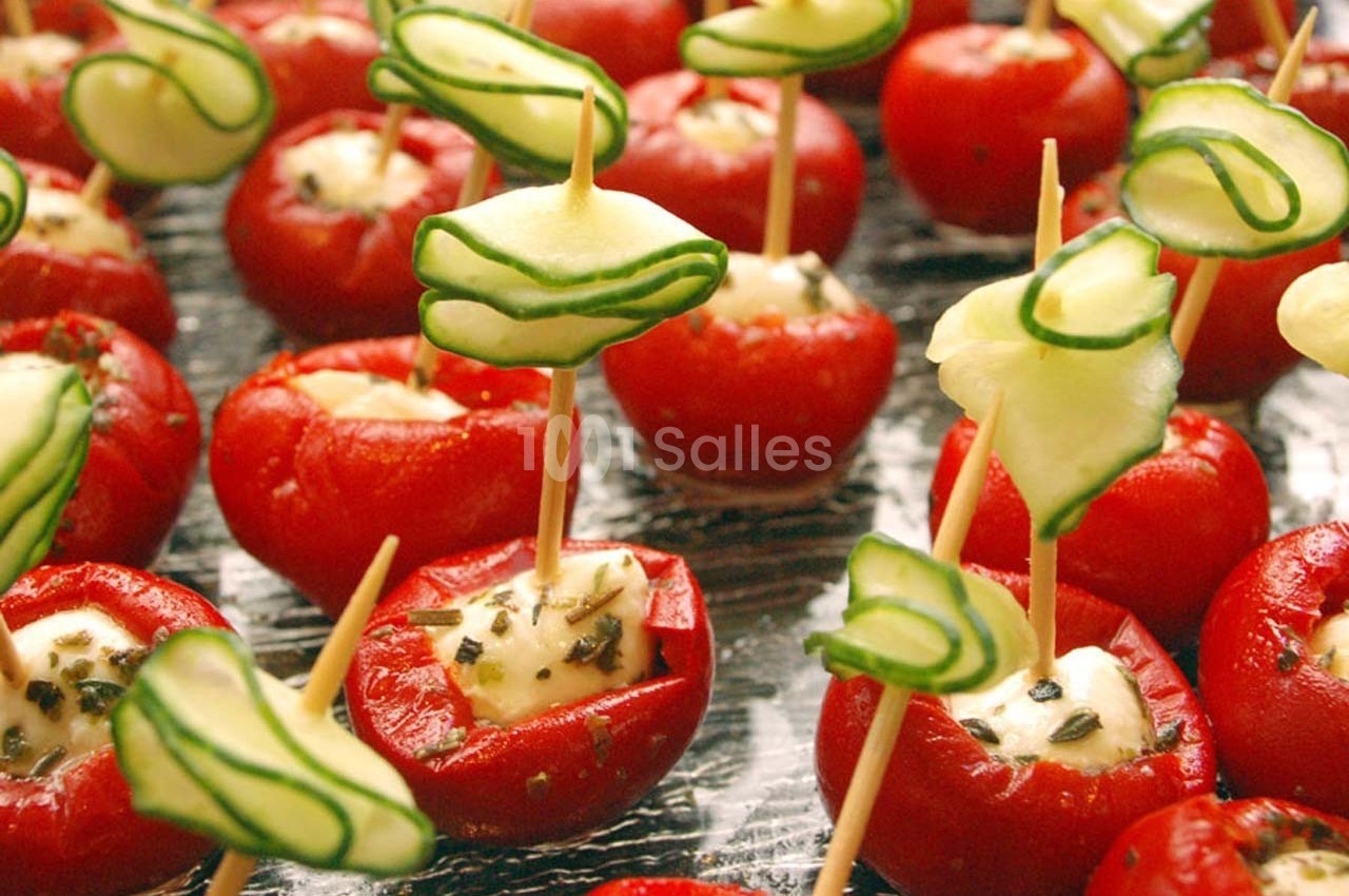 Tomates cerises farcies au fromage frais, décorées de tranches de concombre sur des piques en bois.