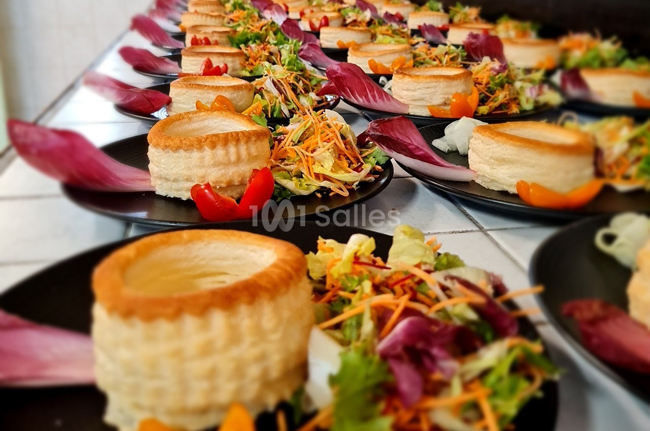 Assiettes dressées avec des bouchées feuilletées garnies, accompagnées de salade colorée et de légumes frais.