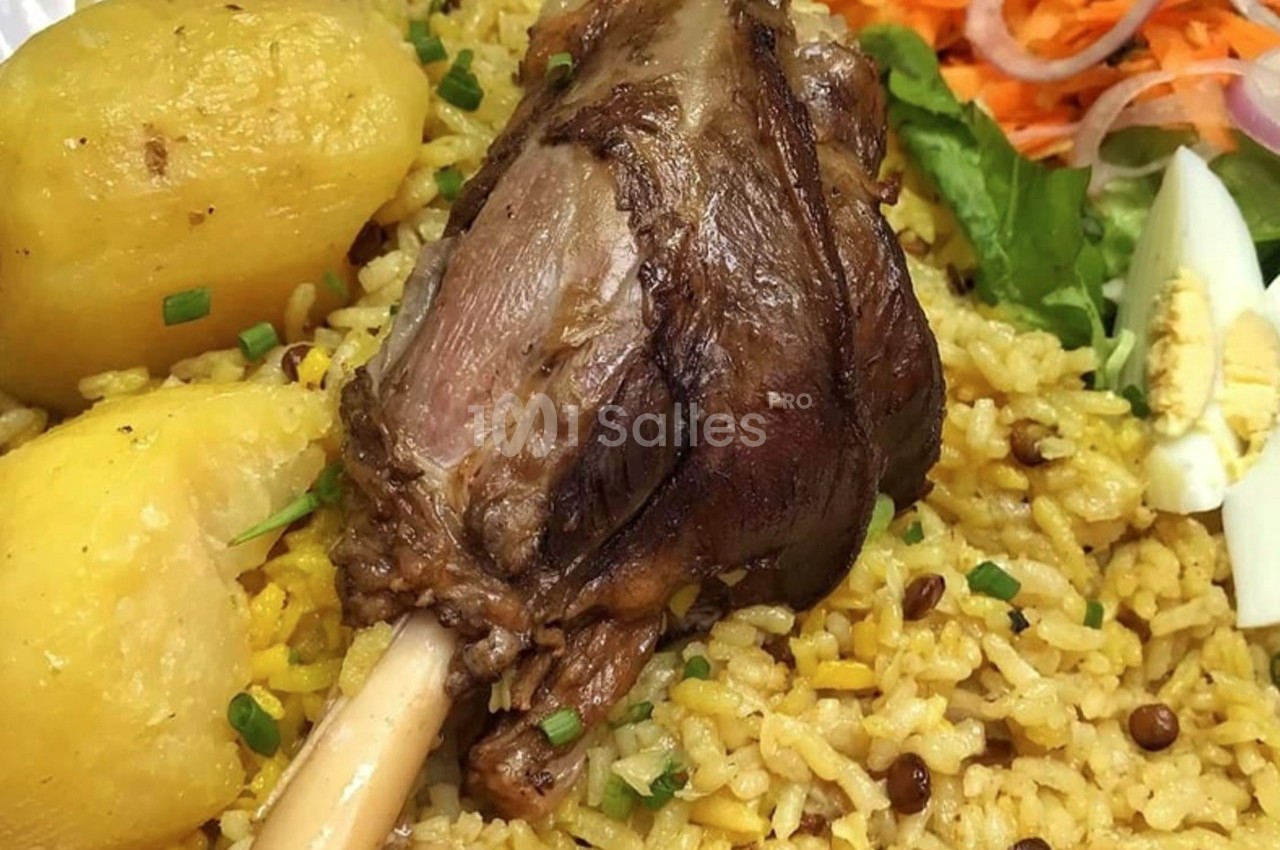 Plat de riz jaune aux lentilles, accompagné d'un jarret d'agneau rôti, pommes de terre, œuf dur et crudités.