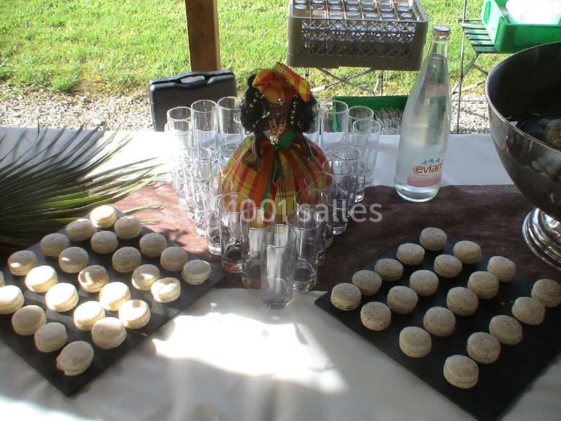 Plateau de macarons disposés autour de verres et d'une bouteille d'eau sur une table décorée.