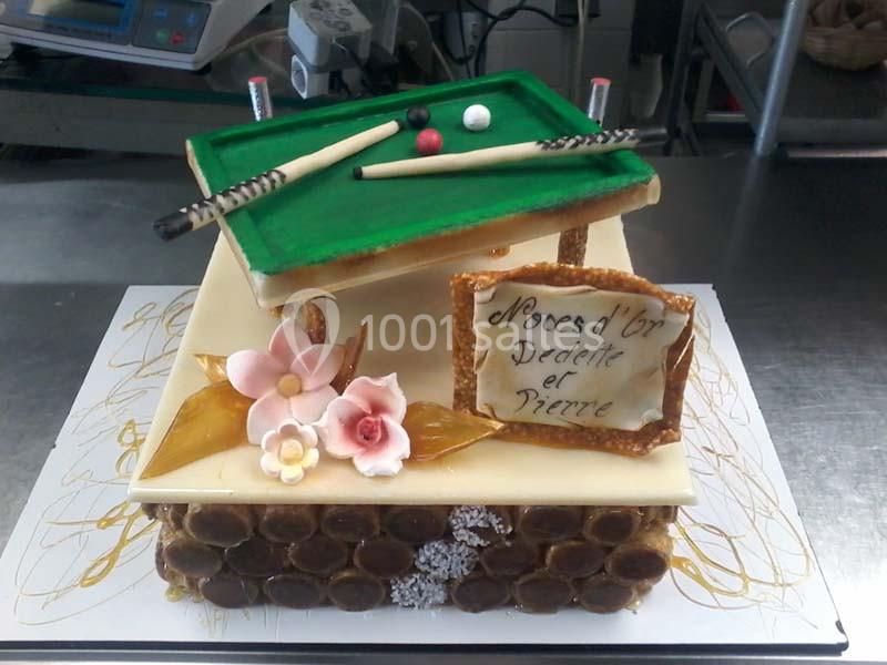 Gâteau décoré en forme de table de billard avec fleurs en sucre et panneau indiquant ’Noces d'or Dedette et Pierre’.