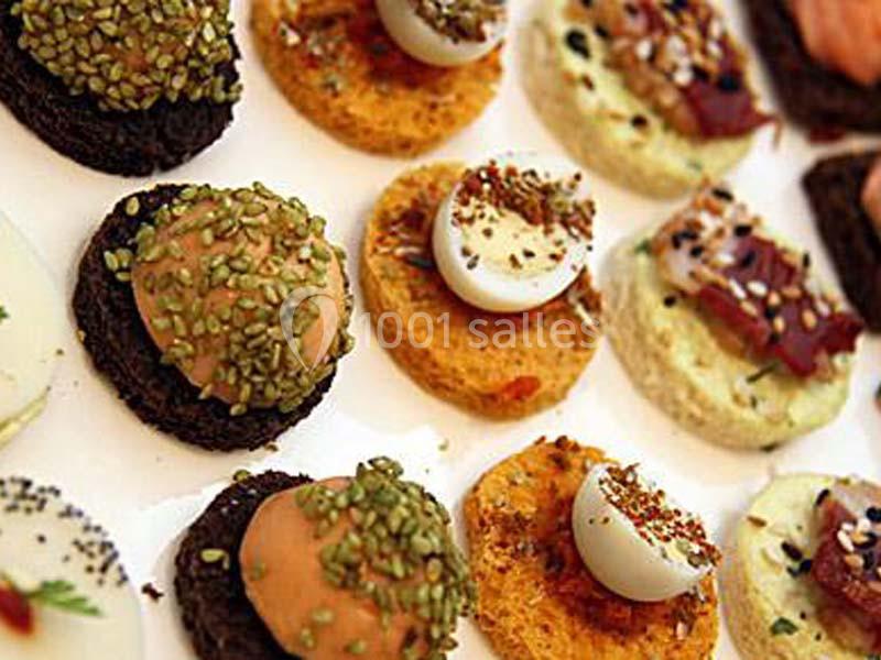 Assortiment de canapés variés avec garnitures colorées, disposés sur un plateau blanc.