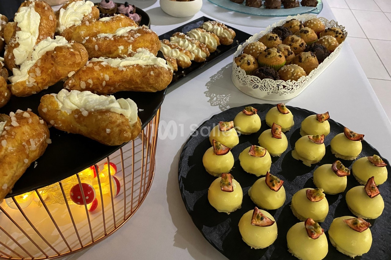 Plateaux de pâtisseries variées, incluant éclairs, choux et desserts décorés de morceaux de fruits.