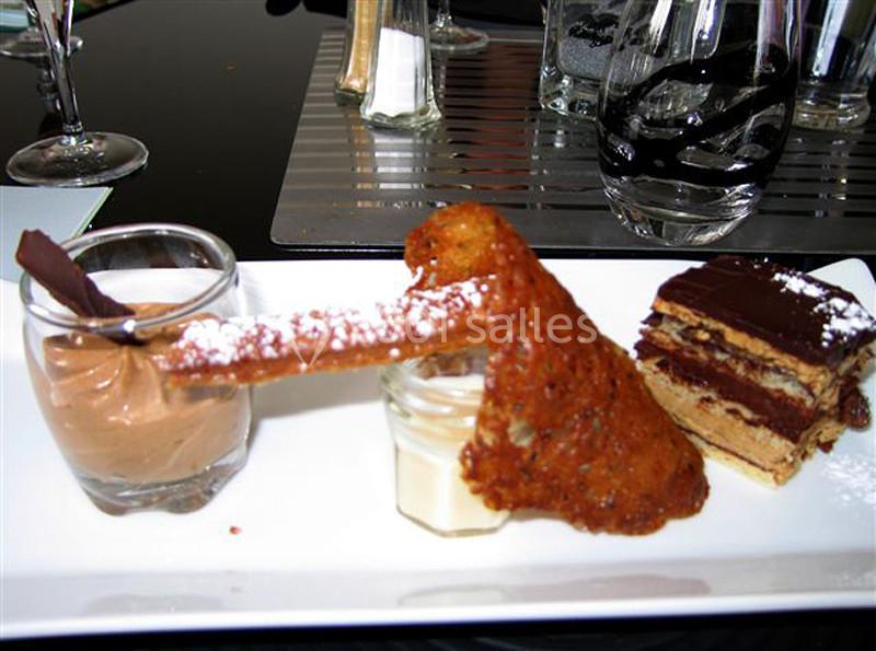 Dessert composé de mousse au chocolat, tuile croustillante, crème blanche et gâteau au chocolat en couches.