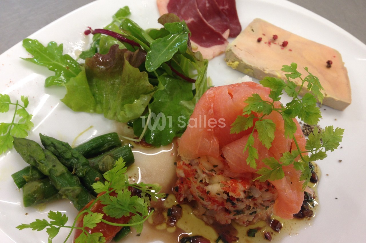 Assiette composée de saumon fumé, tartare, foie gras, salade verte, asperges et viande séchée.