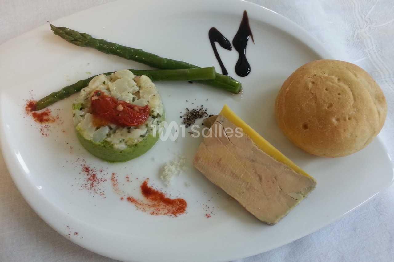 Assiette composée de foie gras, pain, asperges, purée de légumes, tomate séchée et décor de sauce balsamique.