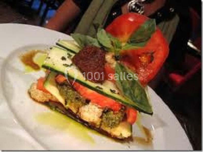 Assiette de légumes grillés en couches avec basilic frais, tomate et filet d'huile d'olive.