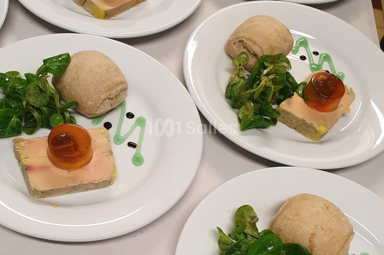 Assiette composée de foie gras, gelée, salade verte, sauce décorative et petit pain.